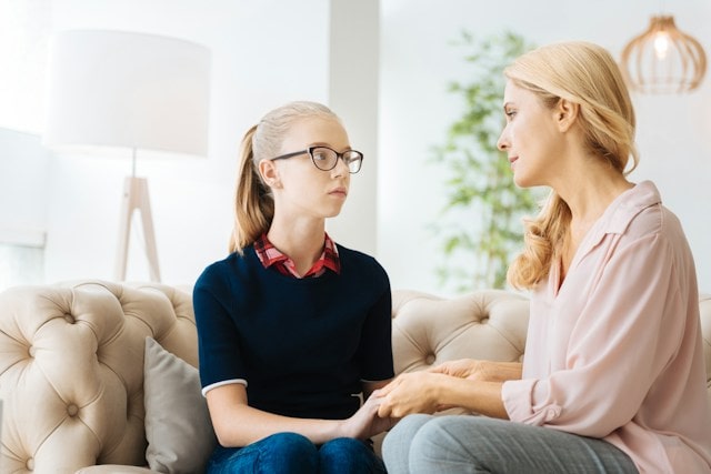 Mother comforting daughter warning signs of suicide in teens